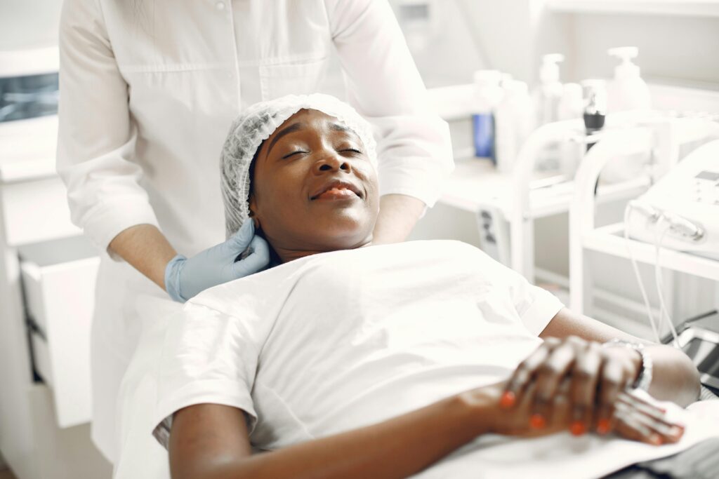 A woman enjoying a relaxing facial massage in a modern aesthetic clinic setting.